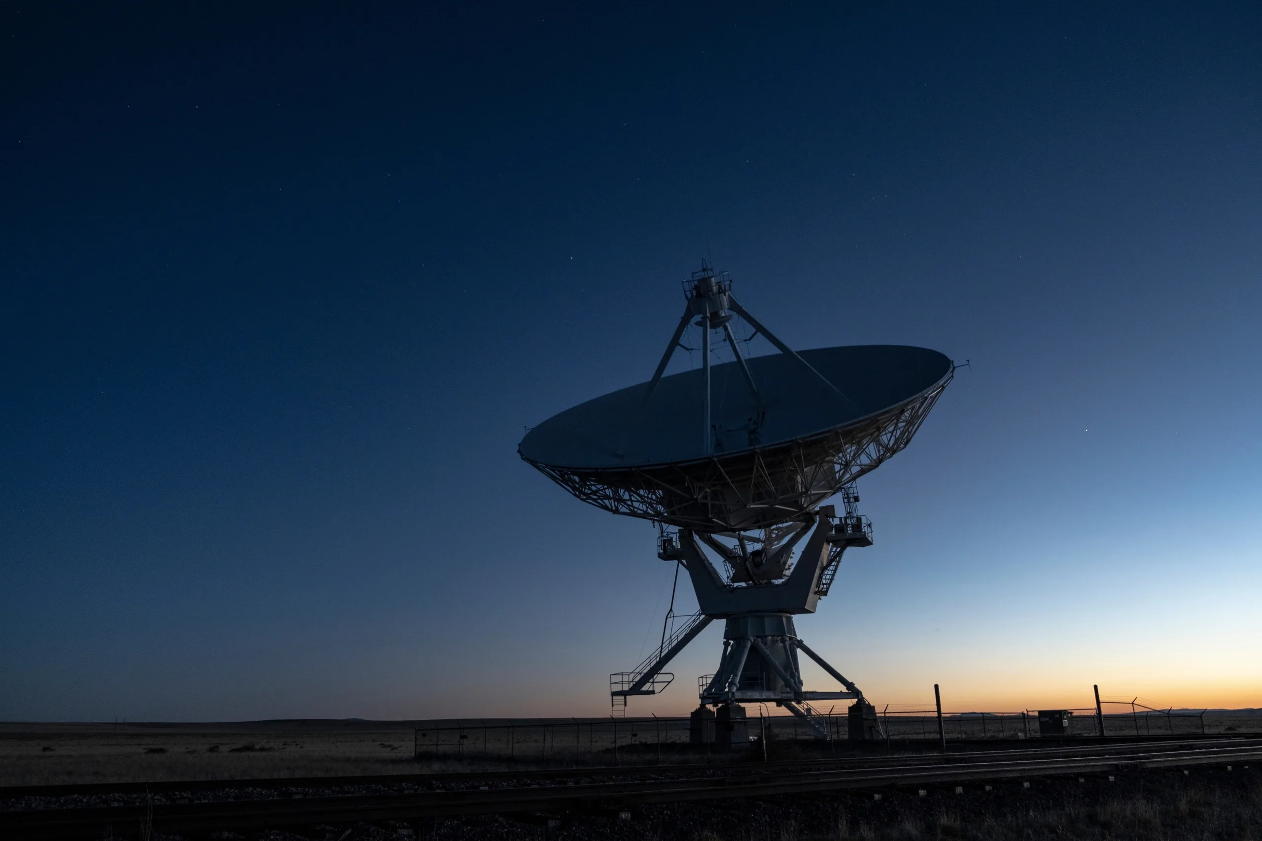 Satellite communication antenna against a sunset sky